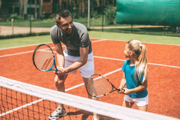 A parent and child on a tennis court