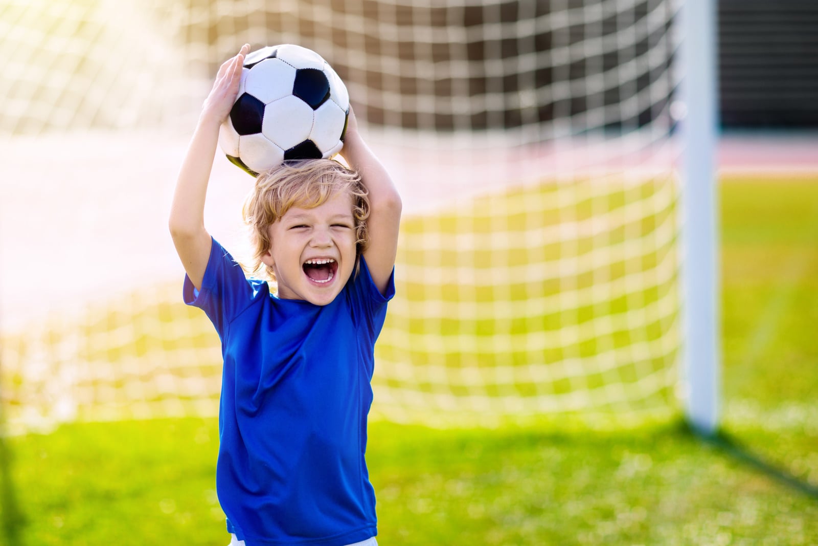A child celebrating with a soccer ball